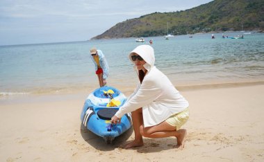 Genç bir çift deniz yolculuğu için mavi bir kano fırlatıyor..