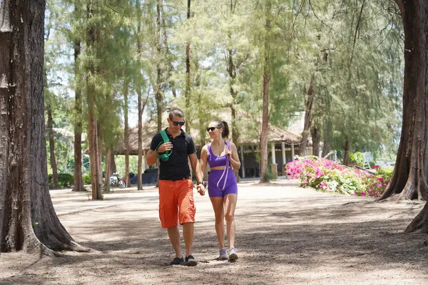 Genç çift parkta direniş bantlarıyla egzersiz yapıyor..