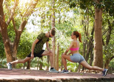 Bir adam ve bir kadın parkta birlikte koştuktan sonra bacaklarını açıyorlar..