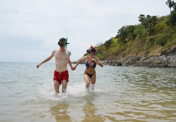 Bir adam ve bir kadın gözlük takıyor ve suyun tadını çıkarıyorlar..