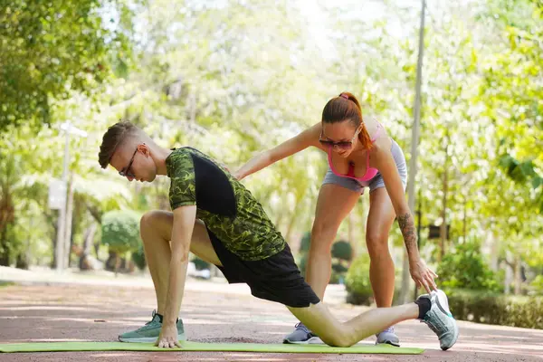 Bir adam ve bir kadın parkta birlikte koştuktan sonra bacaklarını açıyorlar..