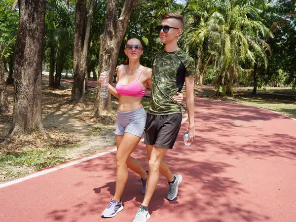 Erkek ve kadın güzel bir parkta yarış yapıyorlar..