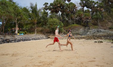 Bir adam ve bir kadın gözlük takıyor ve suyun tadını çıkarıyorlar..