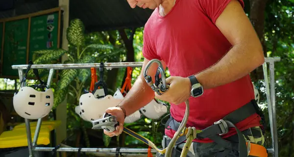 Bir adam heyecanlı bir tırmanışa dikkatle hazırlanır, güvenliğini sağlar..