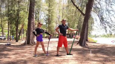 Genç çift parkta direniş bantlarıyla egzersiz yapıyor..