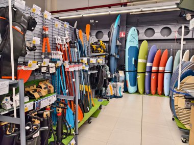 Sörf tahtalarından oluşan bir koleksiyon bir mağazada düzgünce dizilmiş..