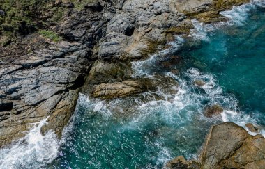 Dalgaların kayalara ve taşlara çarptığı kıyı şeridi..