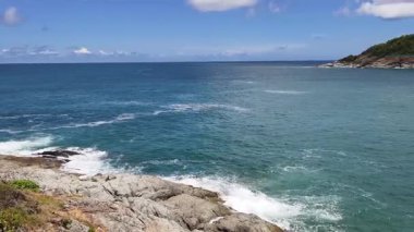 Turkuaz su, kayalık kayalıklar ve yemyeşil tepelerle güzel bir sahil şeridi.