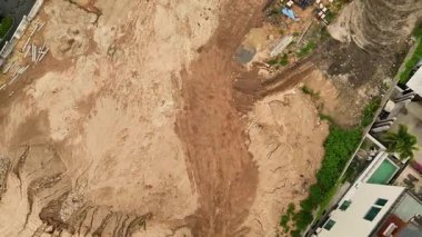 Çeşitli makine ve malzemelerin etrafa saçıldığı yoğun inşaat alanı.