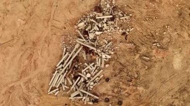 Yapı enkazı kumlu toprağa eşsiz bir şekilde saçılmış ilginç desenler oluşturuyor..