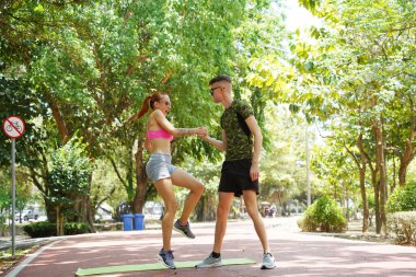Parkta şık güneş gözlüğü takan bir adam ve bir kadın..