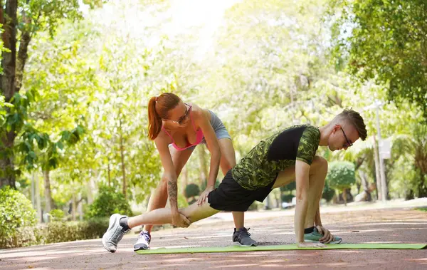 Bir adam ve bir kadın parkta birlikte koştuktan sonra bacaklarını açıyorlar..
