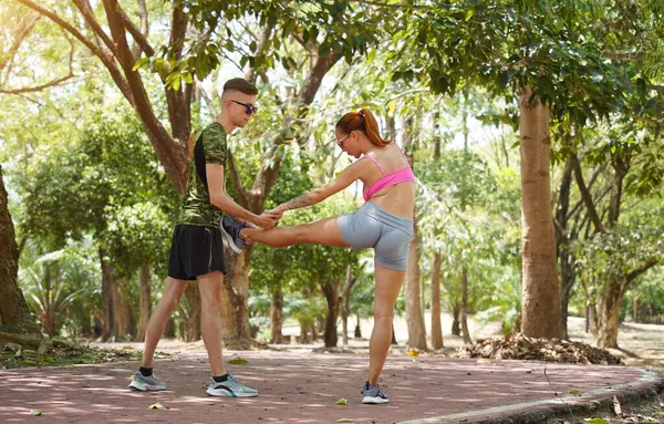 Bir adam ve bir kadın parkta birlikte koştuktan sonra bacaklarını açıyorlar..