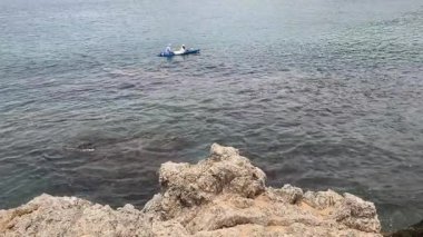 Genç çift, açık mavi bir kanoyla birlikte sarı raketlerle mutlu bir şekilde yol alıyorlar..