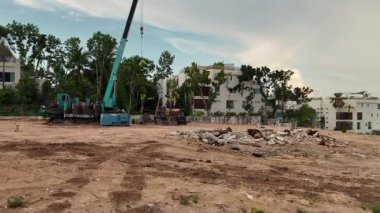 Çeşitli makine ve malzemelerin etrafa saçıldığı yoğun inşaat alanı.