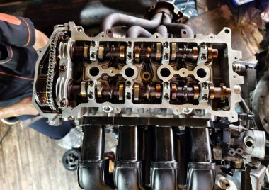 Garaj atölyesinde bir araba motoru tamiri yapılıyor..