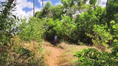 Genç bir çift okyanus manzarası sunan engebeli kayalık bir uçurumda yürüyüş yapıyor..