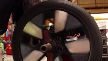 Tam donanımlı bir atölye ortamında dinamik bir lastik döndürme işlemi gerçekleştiriliyor.