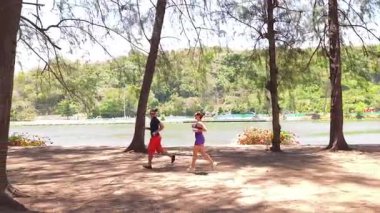 Bir adam ve bir kadın parkta birlikte esneme egzersizleri yapıyorlar..