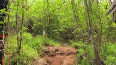 Genç bir çift okyanus manzarası sunan engebeli kayalık bir uçurumda yürüyüş yapıyor..