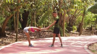 Bir adam ve bir kadın parkta birlikte koştuktan sonra bacaklarını açıyorlar..