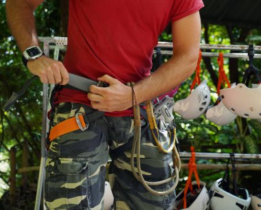 Bir adam heyecanlı bir tırmanışa dikkatle hazırlanır, güvenliğini sağlar..