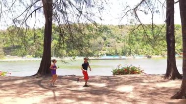 Bir adam ve bir kadın parkta birlikte esneme egzersizleri yapıyorlar..