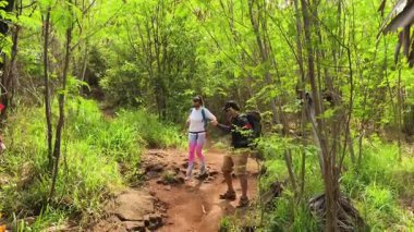 Genç bir çift okyanus manzarası sunan engebeli kayalık bir uçurumda yürüyüş yapıyor..