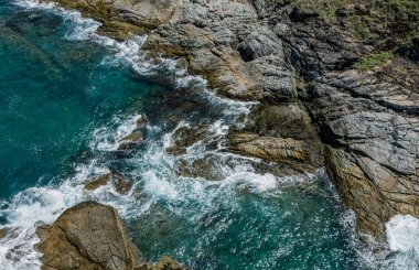 Dalgaların kayalara ve taşlara çarptığı kıyı şeridi..