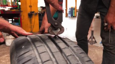 Pratik bir atölye ortamında çeşitli araçları kullanarak etkili lastik onarım teknikleri