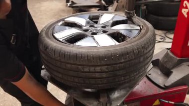 Lastik tutma mekaniklerini gösteren özel makineler kullanılarak lastik değiştirme adımları.