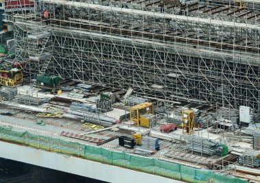 Hareketli bir şehirde bulunan bir inşaat alanını gösteren havadan bir perspektif..