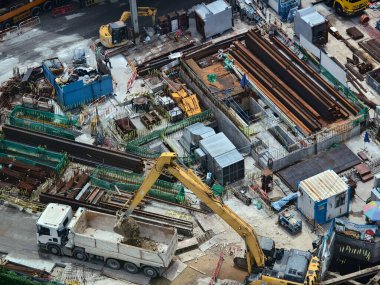 Hareketli bir şehirde bulunan bir inşaat alanını gösteren havadan bir perspektif..