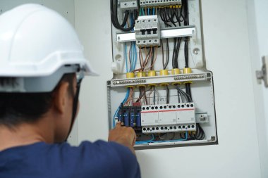 Elektrikçi sigortalı bir santrali kontrol ediyor..