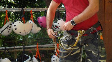 Bir adam heyecanlı bir tırmanışa dikkatle hazırlanır, güvenliğini sağlar..