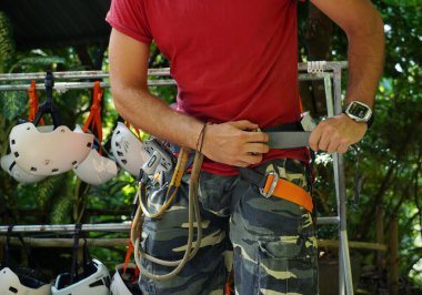 Bir adam heyecanlı bir tırmanışa dikkatle hazırlanır, güvenliğini sağlar..