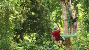 İnsanoğlu, etrafını saran kalın ormandan geçen bir ip üzerinde keyifli bir yolculuğun tadını çıkarıyor..