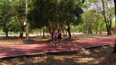 Bir adam ve bir kadın güzel bir parkta birlikte koşuyorlar, temiz havanın tadını çıkarıyorlar.