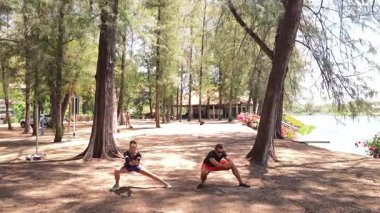 Bir adam ve bir kadın parkta birlikte esneme egzersizleri yapıyorlar..