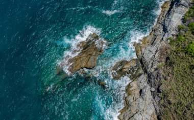Dalgaların kayalara ve taşlara çarptığı kıyı şeridi..