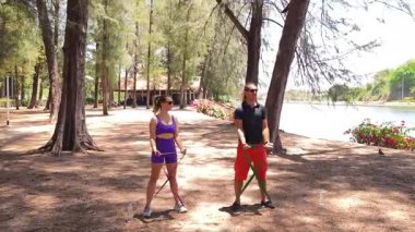 Genç çift parkta direniş bantlarıyla egzersiz yapıyor..