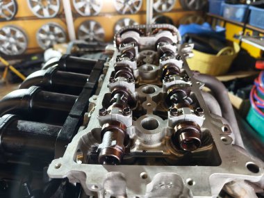 Garaj atölyesinde bir araba motoru tamiri yapılıyor..