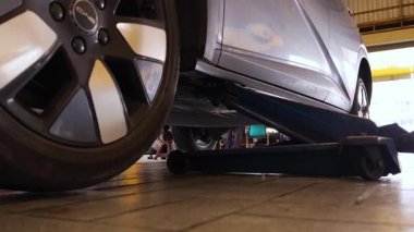 Yetenekli bir tamirci, güvenlik ve bakım sağlamak için lastik değiştirmek için elektrikli bir araç kullanır..