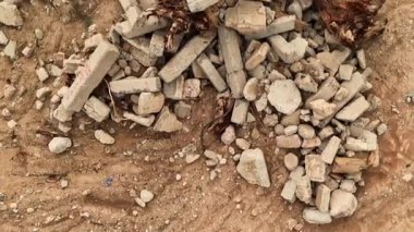 Yapı enkazı kumlu toprağa eşsiz bir şekilde saçılmış ilginç desenler oluşturuyor..