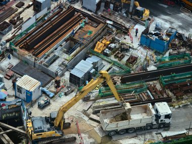 Hareketli bir şehirde bulunan bir inşaat alanını gösteren havadan bir perspektif..