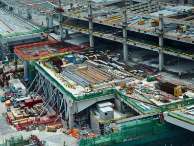 Hareketli bir şehirde bulunan bir inşaat alanını gösteren havadan bir perspektif..