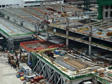 Hareketli bir şehirde bulunan bir inşaat alanını gösteren havadan bir perspektif..