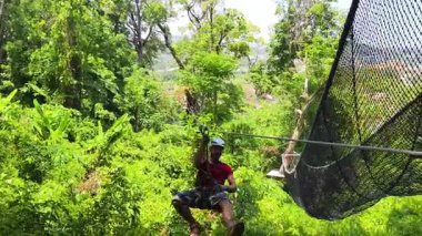 İnsanoğlu, etrafını saran kalın ormandan geçen bir ip üzerinde keyifli bir yolculuğun tadını çıkarıyor..
