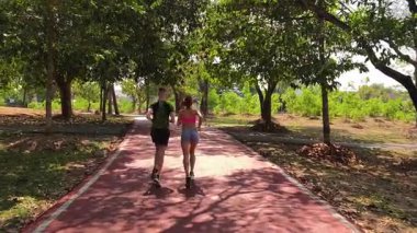 Bir adam ve bir kadın güzel bir parkta birlikte koşuyorlar, temiz havanın tadını çıkarıyorlar.