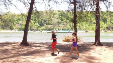 Bir adam ve bir kadın parkta birlikte esneme egzersizleri yapıyorlar..